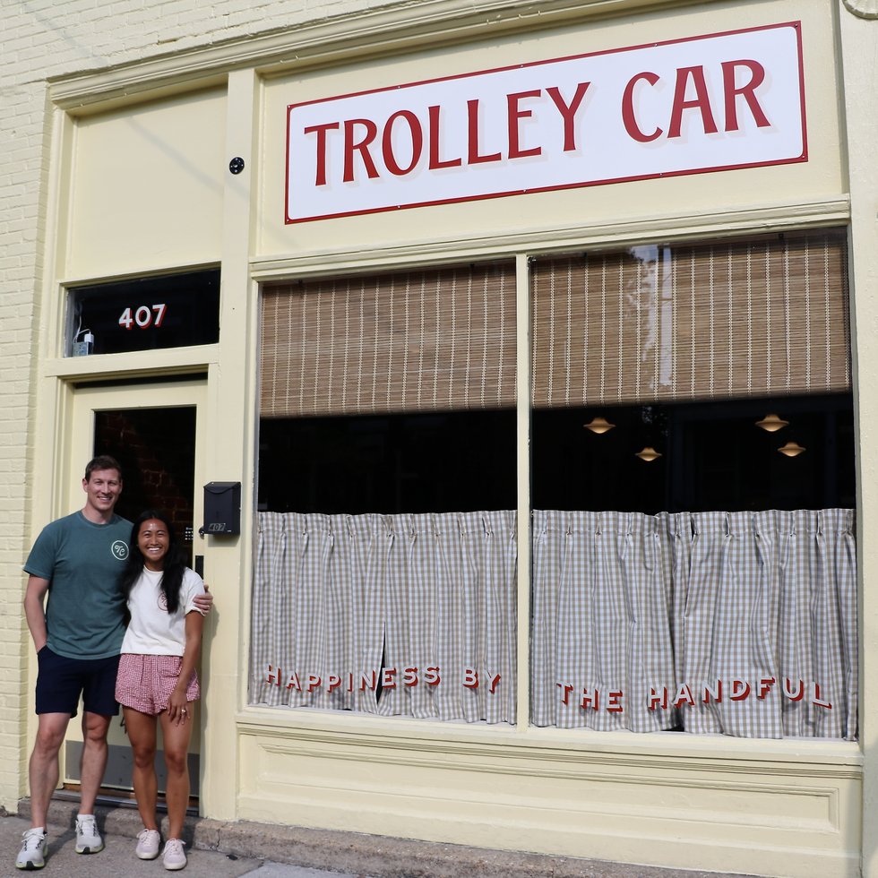 Jacob Horsfall and Nikki Victoria, owners of Trolley Car Sweets and Treats in Richmond Virginia, surrounded by rainbow pick-and-mix candy bins